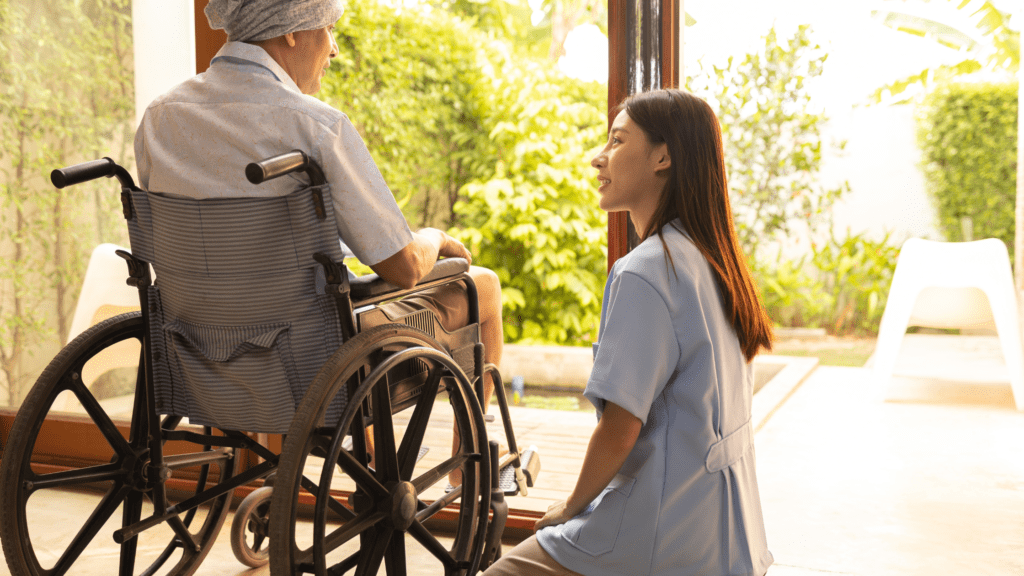nurse speaking to a nursing home resident in a wheelchair