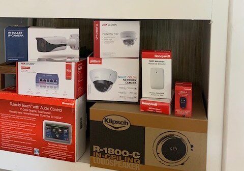 A shelf with boxes of electronics and security cameras.